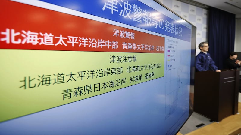 Un funcionario de la Agencia Japonesa de Meteorología se ve junto a una pantalla con una...