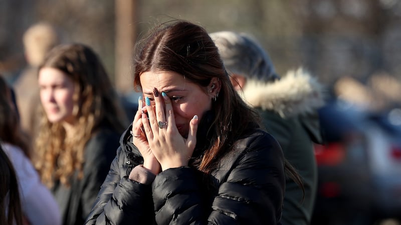 Una mujer se lamenta luego de un tiroteo en una pista de hielo, el lunes 16 de febrero de...