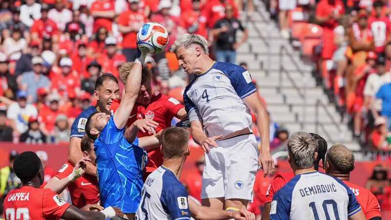 Canada goalkeeper Maxime Crepeau punches the ball clear as Bosnia's Tarik Muharemovic attempts...