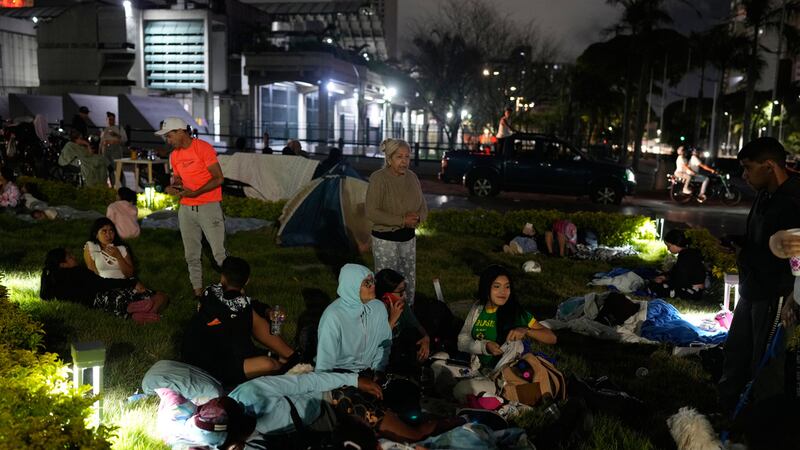 La gente se prepara para pasar la noche al aire libre después de que terremotos sacudieran...