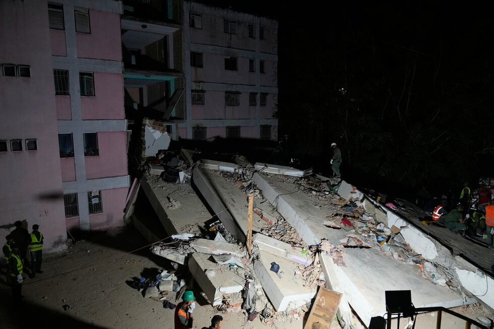 Los equipos de rescate buscan supervivientes entre los escombros de un edificio derrumbado...