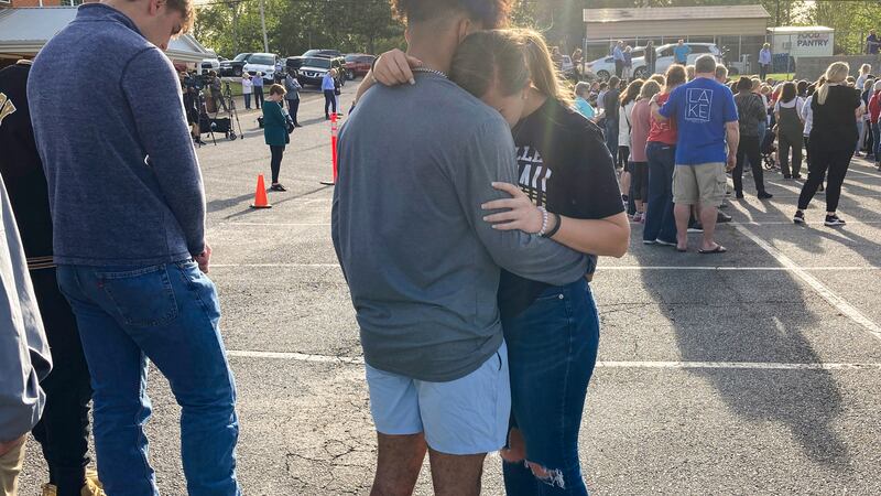 Dos adolescentes se abrazan en una vigilia de oración el domingo 16 de abril de 2023, afuera...