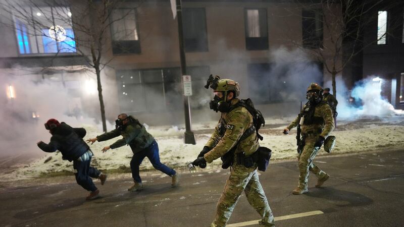 Agentes federales usan gases lacrimógenos para dispersar a manifestantes durante una protesta...
